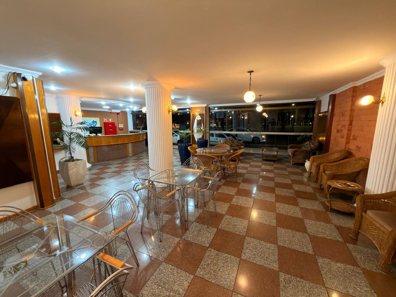 Lobby amplo do Hotel Mello com poltronas e mesas