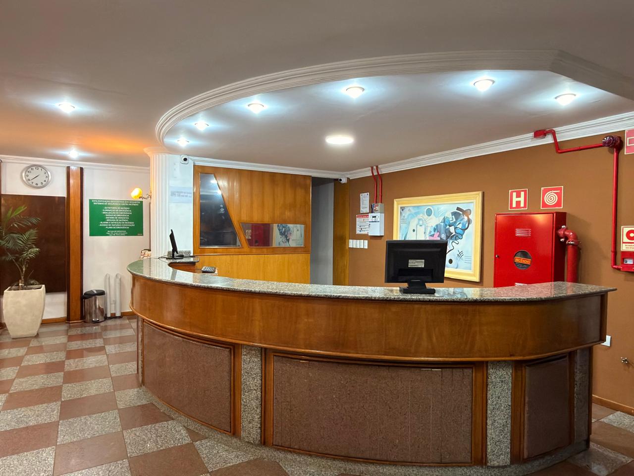 Balcão de madeira da recepção do Hotel Mello em ângulo aberto frontal